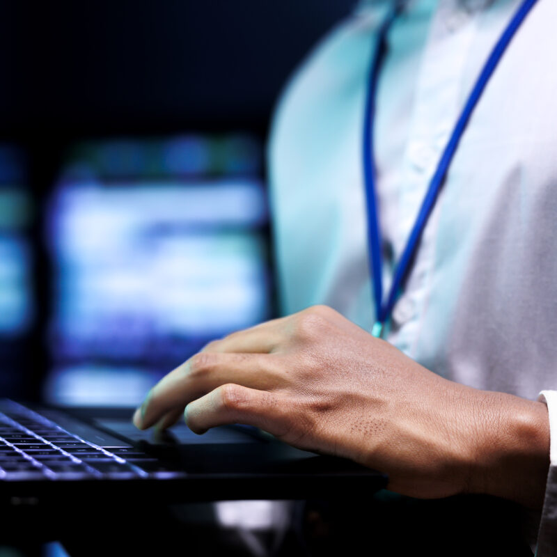 A closeup shot of a man holding a laptop